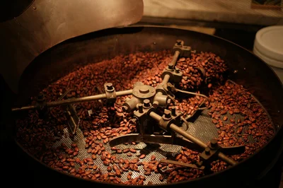 Detailed view of coffee beans roasting in an industrial roaster, showcasing the roasting process.