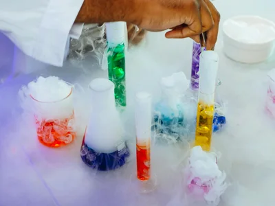 Vibrant chemistry experiment with colorful liquids and smoke in lab glassware.